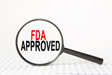 words FDA APPROVED in a magnifying glass on a white background. business concept