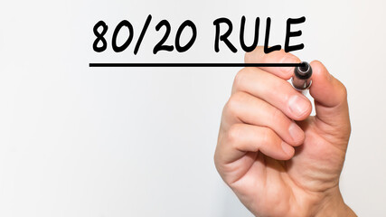 the hand writes text 80 20 RULE with a marker on a white background. business concept