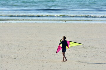children playing kite on a beach in brittany. France 