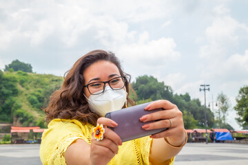 Closeup of a girl with a protective mask looking at a phone - new normal