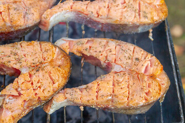 Large fish steaks fresh trout fried in spices on the grill