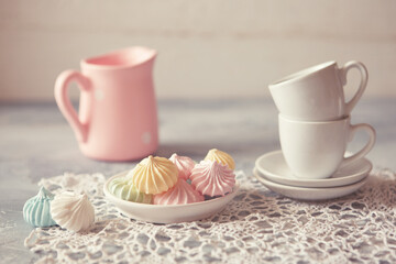 Romantic Breakfast with meringue cookies, white cups and creamer