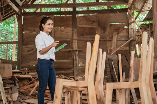 Young women furniture entrepreneurs use tablet pc in furniture workshop