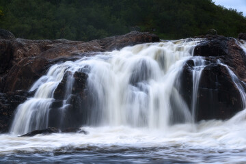 Rapid waterfall flow on the Titovka River in the polar region. Murmansk region, Russia