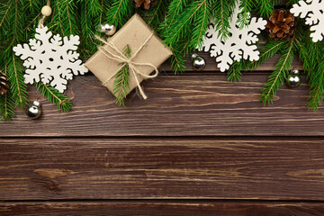 Winter holidays background with fir tree branches, gift box and snowflakes
