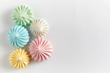 Pastel colored meringue on white background