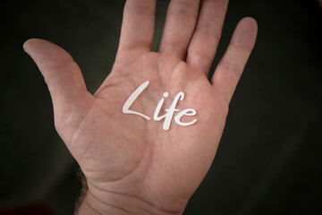 Ausgeschnittener "Life" Schriftzug auf einer Hand