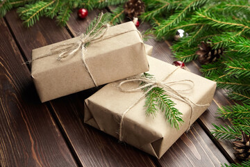 Christmas gift boxes with fir tree branches on wooden background