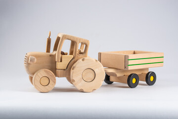 wooden kids tractor toy with trailer isolated on white background, close view 