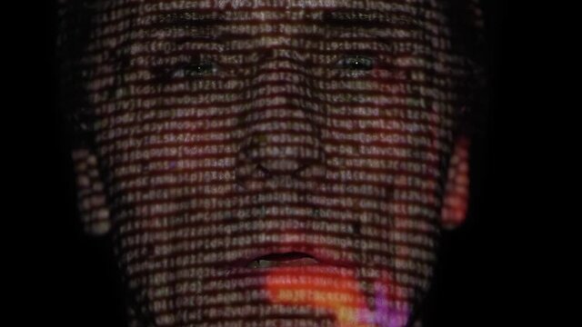 In the dark, a man's face reflects a film, clip, advertisement, video content that he is watching. Different emotions on the face. Wears 3D glasses for watching a stereo movie. Closeup
