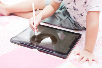 Kid using technology to write and draw expressing their creativity. A concept of digital learning.