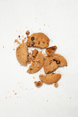 One broken Chocolate chip cookie isolated on white background. Sweet biscuit crumbs. Homemade pastry