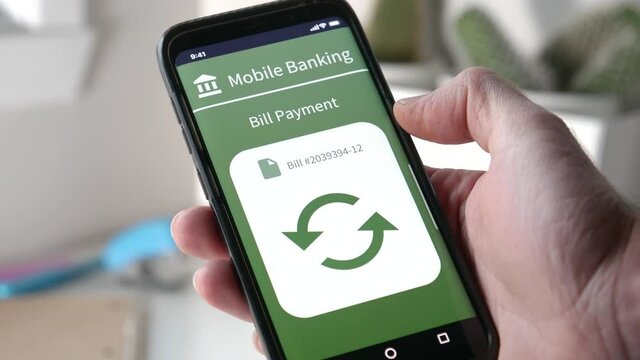 Using a mobile phone to pay for a bill using the online bank account. Banking online using a smartphone