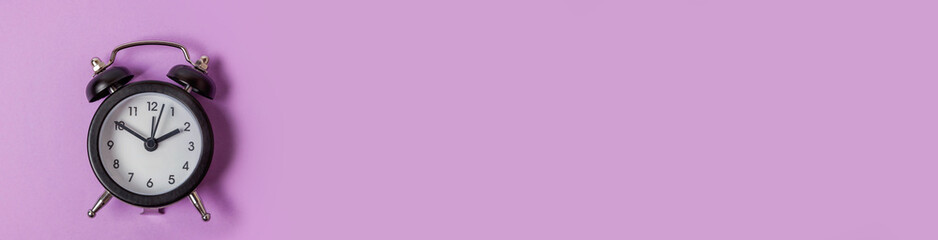 Simply minimal design ringing twin bell vintage classic alarm clock Isolated on purple background....