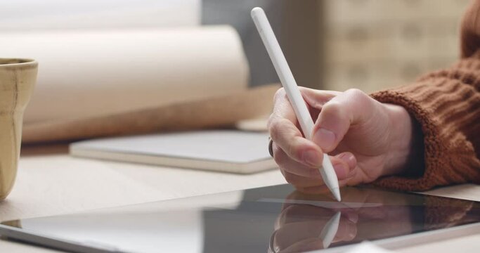 Close up view of person hands creating picture on tablet at worlplace. Graphic designer using stylus, zooming and touching screen while drawing illustration. Concept of modern art