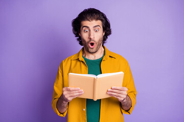 Photo of young arabian man hold book notebook read shocked amazed information isolated over violet...