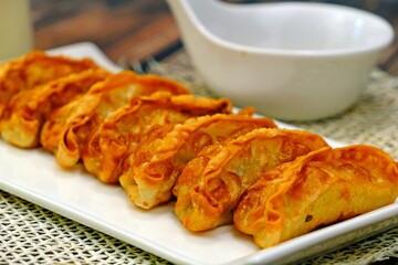 Pan fried Chinese dumplings (Jiaozi, Gyoza) in white plate ready to serve.