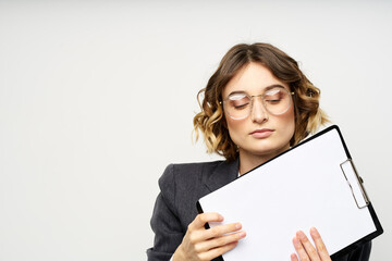 Naklejka premium Business woman with a folder of documents on a light background cropped view and shirt suit