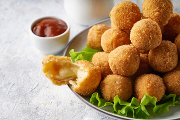 cheese balls, appetizer with herbs and sauces in a plate on a gray table