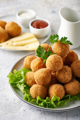 cheese balls, appetizer with herbs and sauces in a plate on a gray table