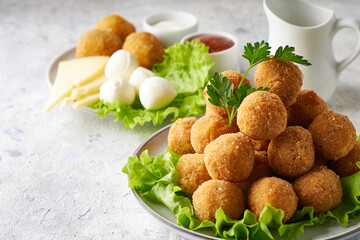 cheese balls, appetizer with herbs and sauces in a plate on a gray table