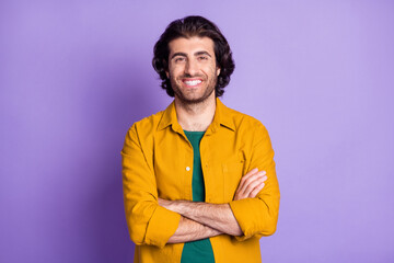 Photo of cheerful young man happy smile positive crossed hands isolated over violet color background