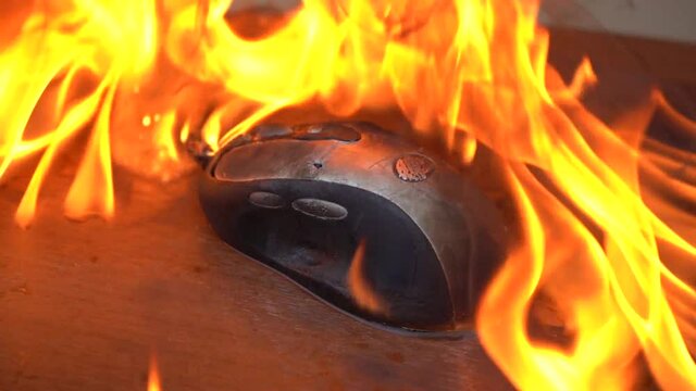 Burn the computer mouse. Close-up. Concept, a computer mouse caught fire from overload and intense work.