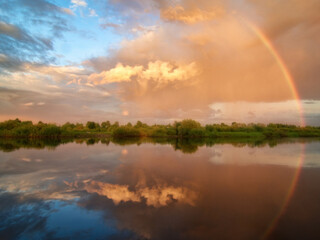 Rainbow in the sky after a thunderstorm. Tver region, the merging of the rivers Mologa and Autumn