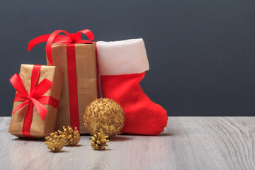 Gift boxes, Santa's boot and toy ball on gray background