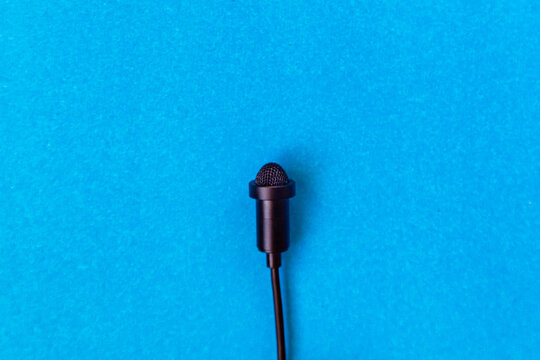Small size audio microphone on a blue background Copy space