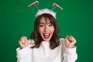 Beautiful excited girl wearing toy horns screaming and looking at camera