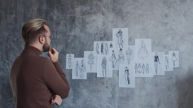 Workplace of young and talented fashion designer. Tailor works in stylish loft using sketches of clothes.