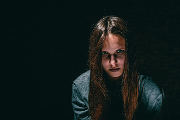 portrait of young teenager brunette girl with long hair in the Gothic style on a black background