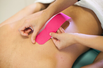 Back treatment with pink physio tape
