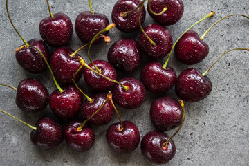 Juicy cherry close up photo. Water drops on fresh berries. Dark grey textured background. Healthy eating concept. 