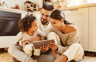 happy multi ethnic family: parents and son using tablet  at home