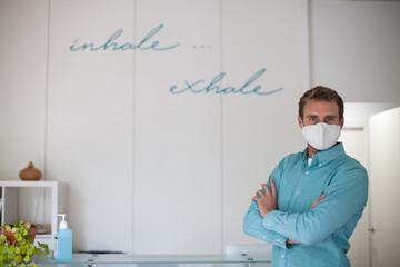 young man wearing mask at the reception of modern fitness club during covid-19