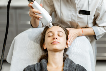 Portrait of a young woman during a facial rejuvenation treatment at medical SPA. LaseMD procedure...