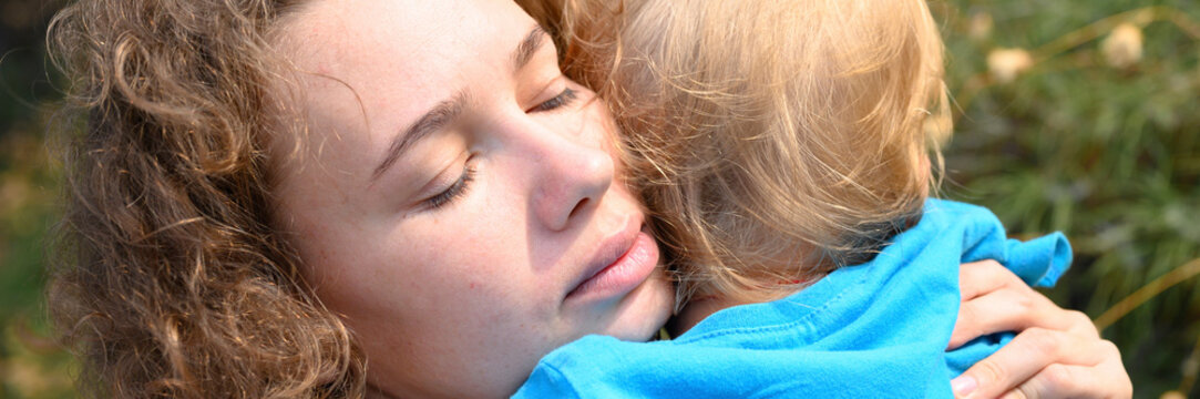 Mom Holds Her Little Baby Boy In Her Arms, To Feel Sorry, The Child Hugs His Mother And Snuggles Up To Her. Banner