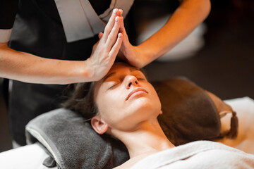 Fototapeta na wymiar Young woman receiving a facial massage, relaxing at Spa salon
