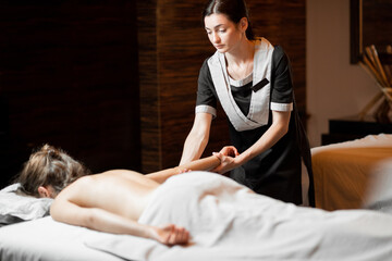 Obraz na płótnie Canvas Professional female masseur doing a back massage to a young woman at Spa salon