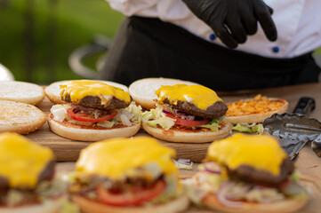 The chef cooked hamburgers with beef patty, cheddar cheese and vegetables.