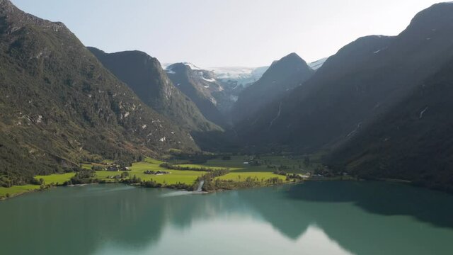 Glacial Lake and Picturesque Green Valley Under Glacier in Countryside of Norway Aerial View. Oldevatnet, Oldenelva River and Briksdalbreen Glacier on Sunny Summer Day, Drone Shot