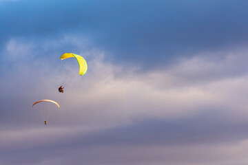 Paragliders against snow-capped Andes mountains during winter season in Esquel, Patagonia, Argentina