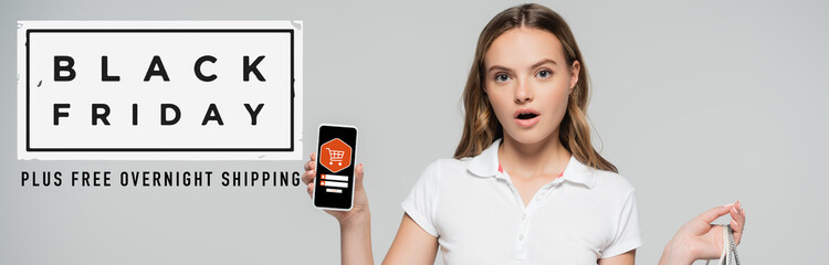 shocked woman holding smartphone near black friday lettering and illustration on grey, banner