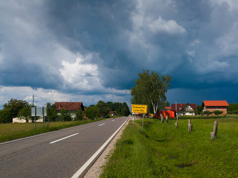 Main road in the village of Bosansli Lužani, Derventa during a storm with gloomy dark clouds