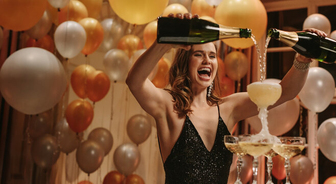 Excited woman filling up pyramid of champagne