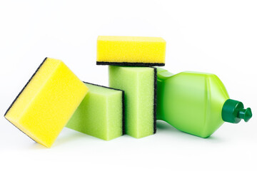 Bottle of dishwashing detergent and colorful sponges on white background.