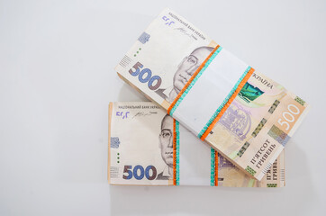 two bundles of Ukrainian hryvnia on a white background.