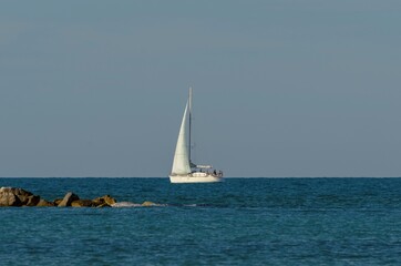 Fototapeta premium Sailboat in the middle of the sea near the coast
